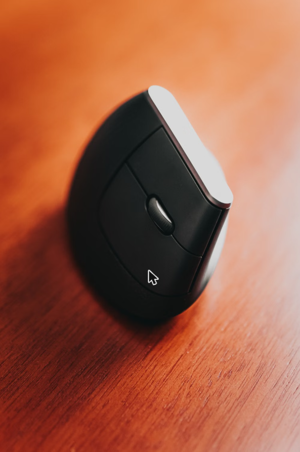Close-up of a black vertical ergonomic mouse on a desk, the kind of grip that takes pressure off the wrist