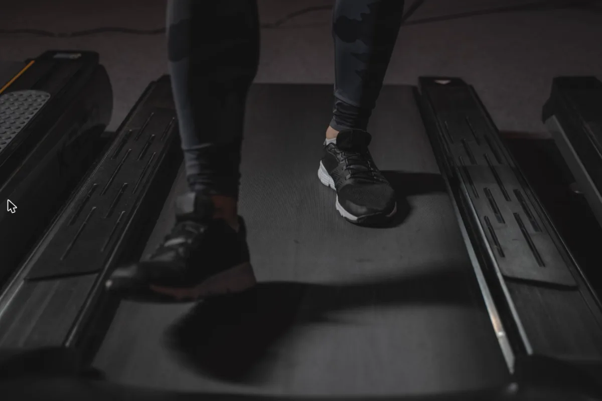 Feet walking on the belt of an under desk treadmill for home office use at desk pace